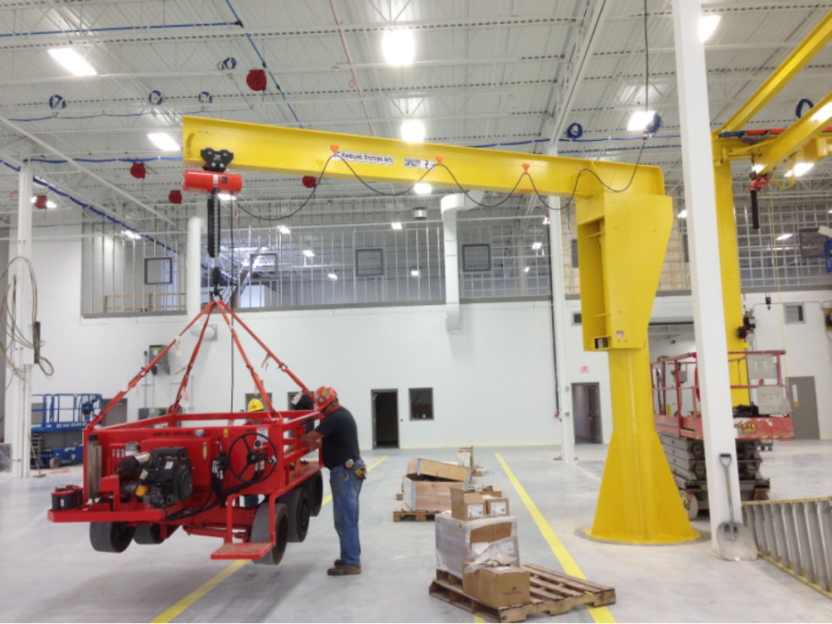 A picture of a HSI Crane being used to lift machinery inside a warehouse.