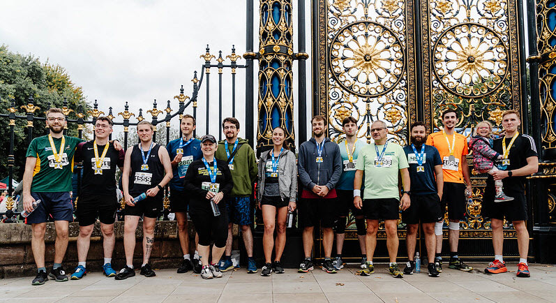 A photo of the DriveWorks team in front of the Warrington Golden Gates with their medals