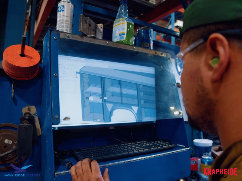 A picture of a Knapheide employee looking at a 3D model inside a warehouse.